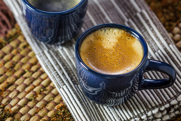 Two blue cups of coffee on napkin