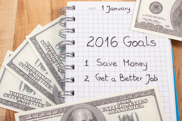 Obraz premium New years resolutions written in notebook and currencies dollar