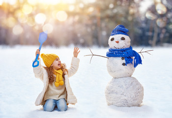 girl playing with a snowman