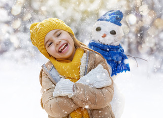 girl playing with a snowman