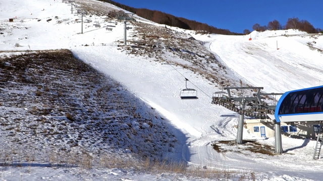 Skiers on chairlift photographed from behind