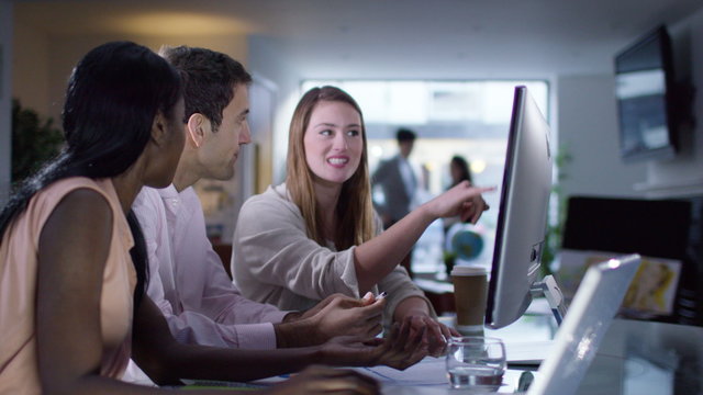  Business group working side by side in office and discussing their work