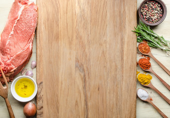 Food background with raw meat steaks and seasoning. Concept of ingredients for cooking steak, top view of the raw meat, chopping board in the middle, virgin Olive Oil and spice.