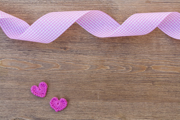 Valentines day crochet hearts and ribbon on wooden table