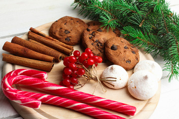  viburnum with Christmas candy and cinnamon on a cutting Board on wooden table