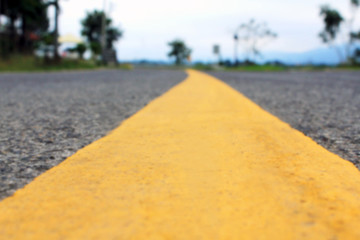 Fototapeta premium Close up yellow line on road, divide road,dreamy, blur picture
