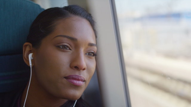 Beautiful woman with earphones relaxing on train journey