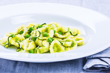 Italian pasta, orecchiette with green peas and zucchini sauce.Vegetarian dish.