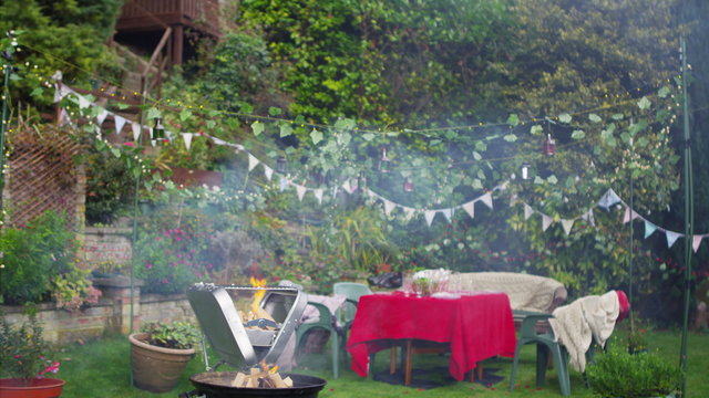  Outdoor summer party scene with flaming bbq, party banners and string lights