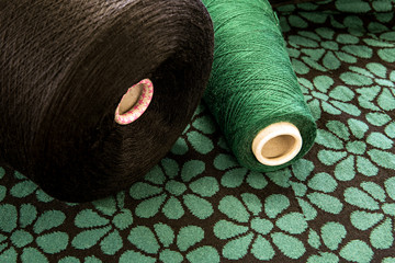 Spools of Brown and Green Thread on Floral Surface