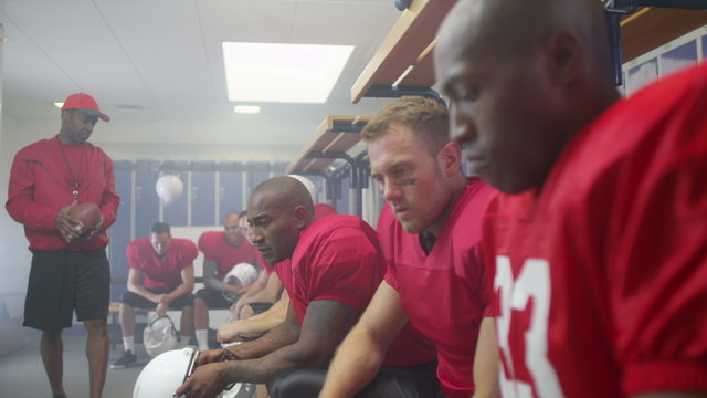  portrait of serious American football player in team locker room