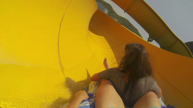 Fun with girl on the water slide in aqua park