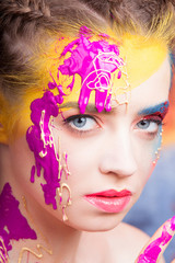 Portrait of beautiful young woman with paint on face 