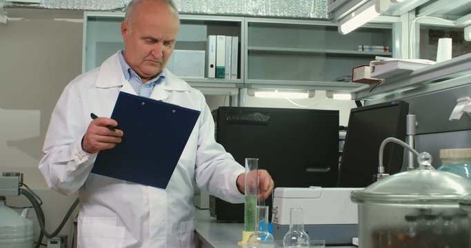 Mature chemist working on his research in modern laboratory