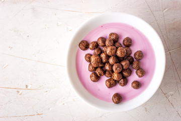 Fruit yogurt with crisp chocolate ball in the ceramic bowl top view