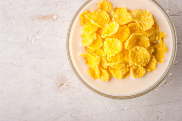 Natural yogurt in glass bowl with cornflakes top view