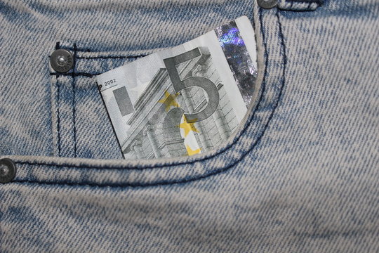 Dinero en efectivo en el bolsillo delantero de un pantal&oacute;n vaquero
