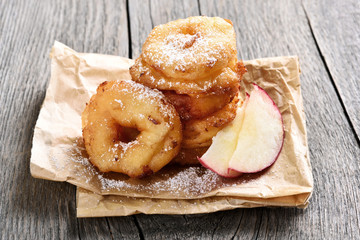Apple rings over baking paper on rustic table