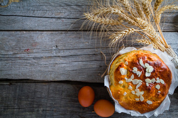 Easter bread and ingredients on rustic wood background