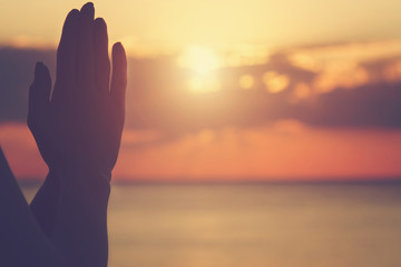 Young woman practicing yoga on the beach.