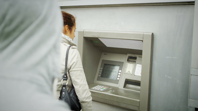  Suspicious Character Waits Behind A Woman As She Takes Money From ATM Machine