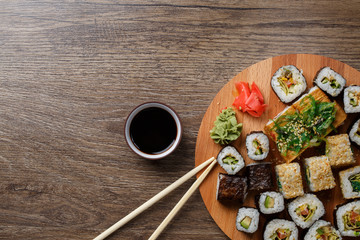 Obraz na płótnie Canvas Sushi set at round wooden plate 