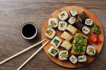 Fototapeta na wymiar Sushi set at round wooden plate 