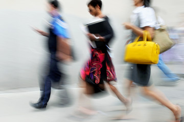 motion blurred business people walking on the street