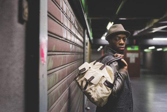 Half length of young handsome afro black man holding a bag, lean