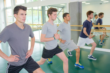 Fototapeta premium Four young men exercising in gym