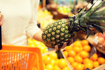 close up of woman with pineapple in grocery market - Powered by Adobe