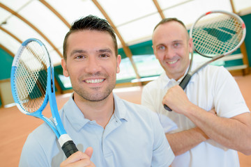 Two men holding tennis rackets