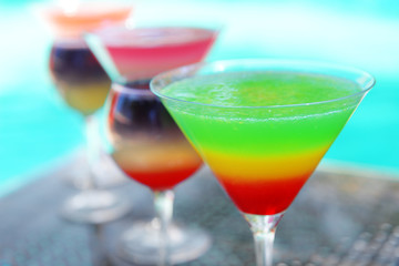 Cocktails on swimming pool background