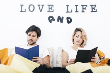 Young students couple reading books in bed