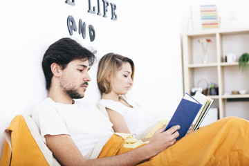 Young students couple reading books in bed