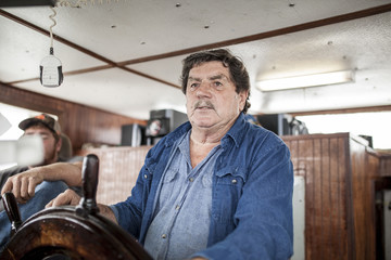 fishing vessel captain at the helm