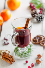 Mulled wine with fruits and spices on snow covered table.