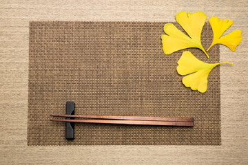chopsticks and fallen leaves on the place mat