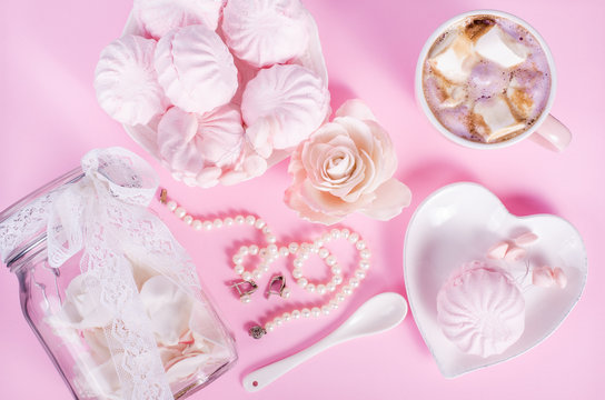 Cute set of pink princess accessories and sweets. Bottle with mastic flowers, big peach rose, zefir, cup of cacao with marshmellow, little spoon and pearl jewerly.