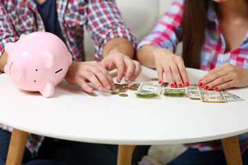 Fototapeta premium Happy couple counting money from the moneybox