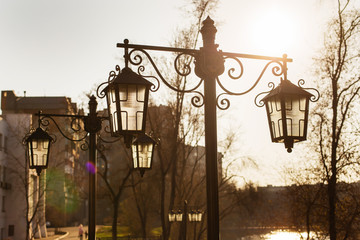 Vintage street lamps against backlight on sunset background