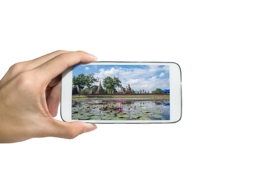 Holding a smart phone ,Take a picture Sukhothai historypark, Sukhothai , Thailand.