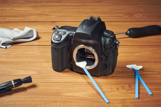 Digital photo camera with cleaning tools
