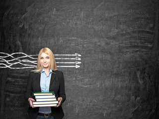 girl with books in front of blackboard