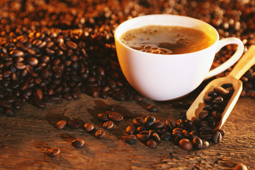 Cup of coffee and coffee beans on table