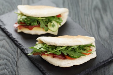 rustic sandwiches with ham arugula and tomatoes in pita bread 