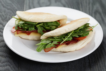 rustic sandwiches with ham arugula and tomatoes in pita bread 