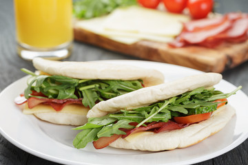rustic sandwiches with ham arugula and tomatoes in pita bread 