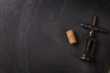 Vintage corkscrew and cork on stone table