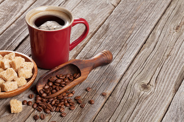 Coffee cup, beans and brown sugar on wooden table